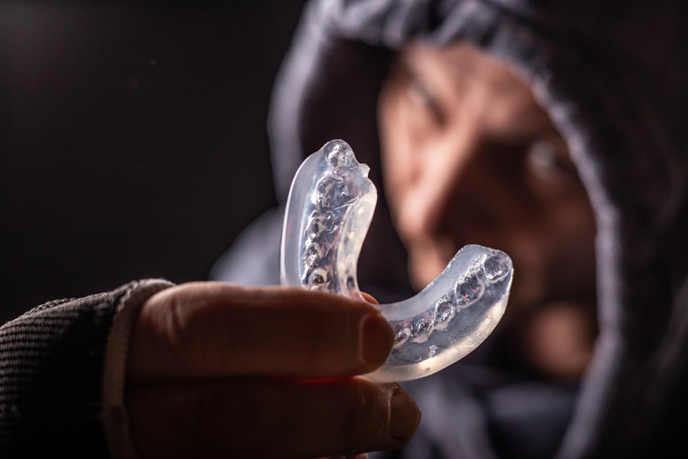 Person holding a clear mouthguard